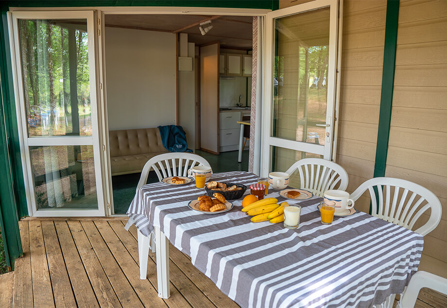 Terrasse couverte de la location bungalow Classic 5 personnes dans le Tarn au camping 4 étoiles le Chêne Vert. Location vacances près de Gaillac