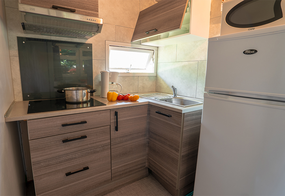 Vue d’ensemble de la location bungalow Eco 5 à 6 personnes 3 chambres, dans le Tarn avec terrasse couverte et meuble de jardin du camping 4 étoiles le Chêne Vert près de Gaillac.