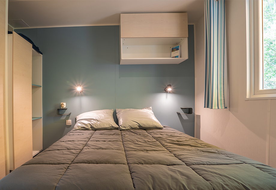 La terrasse couverte du mobil-home 4 personnes Premium + 2 chambres, dans le Tarn avec transats, du camping 4 étoiles le Chêne Vert près d’Albi